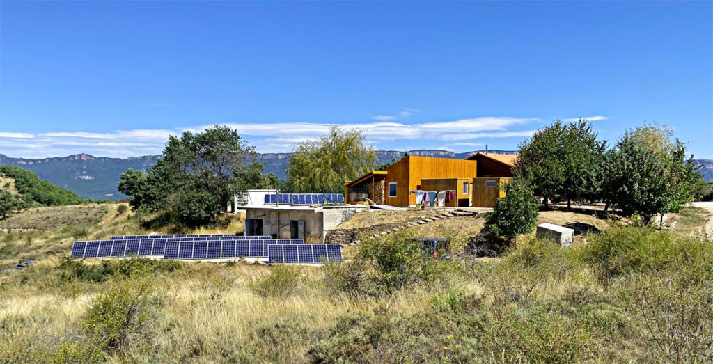 Vista general de la escuela de yoga witryh donde pueden verse lso paneles fotovoltaicos y el paisaje