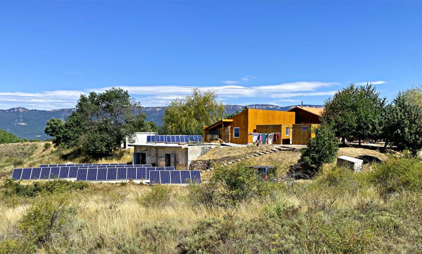 Vista general de la escuela de yoga witryh donde pueden verse lso paneles fotovoltaicos y el paisaje